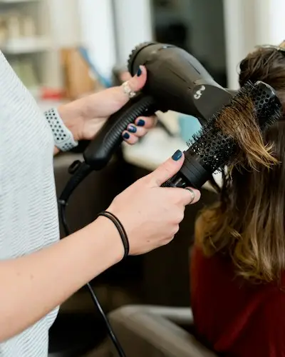 Cabeleireira escovando o cabelo de uma cliente